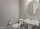 A charming powder room features a pedestal sink, modern toilet, and a decorative mirror at 36172 N Secret Garden Path, Queen Creek, AZ 85140