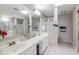 Bathroom with a double sink vanity, mirrors, tiled floors, and glass enclosed shower and tub area at 3755 E Broadway Rd # 36, Mesa, AZ 85206