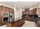 Modern kitchen featuring dark wood cabinets, stainless steel appliances, granite countertops, and pendant lighting at 4332 S Oregon Ct, Chandler, AZ 85248