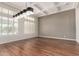 Bright living room featuring hardwood floors, coffered ceilings, a modern light fixture, and shuttered windows at 4332 S Oregon Ct, Chandler, AZ 85248