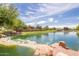 Scenic pond view in a well-maintained community, with lush greenery and blue skies at 4332 S Oregon Ct, Chandler, AZ 85248
