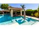 This outdoor pool has a swim-up bar, lounge chairs and nearby lush landscaping at 4332 S Oregon Ct, Chandler, AZ 85248