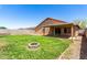 Well-maintained backyard with green grass, firepit, privacy fence and a covered patio at 4837 E Whitehall Dr, San Tan Valley, AZ 85140