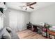 Bright bedroom features ceiling fan, wood floors, sheer window coverings, and gray futon at 4837 E Whitehall Dr, San Tan Valley, AZ 85140