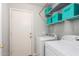 Bright laundry room with storage shelves, washer, dryer, and a convenient utility door at 4837 E Whitehall Dr, San Tan Valley, AZ 85140