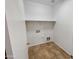 This laundry room has tile floors and features shelving and the hook ups for a washer and dryer at 5339 W Maldonado Rd, Laveen, AZ 85339