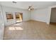 Open-concept living room with tile flooring, a sliding glass door to the backyard, and a bright, airy feel at 5339 W Maldonado Rd, Laveen, AZ 85339