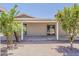 Relaxing covered patio with desert landscaping, offering privacy and an inviting outdoor living space with mature flowering trees at 662 W Elena Ave, Mesa, AZ 85210