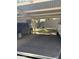 Designated parking area with covered spaces and a glimpse of a grassy landscape beyond at 700 E Mesquite Cir # J135, Tempe, AZ 85288