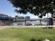 Picturesque waterfront view featuring a grassy lawn, park signage, and distant buildings at 700 E Mesquite Cir # J135, Tempe, AZ 85288