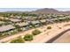 A high-angle shot of a residential neighborhood featuring a luxurious pool, landscaping and mountain views at 7002 S Portland Ave, Gilbert, AZ 85298