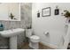 Charming powder room featuring unique tiled wall, pedestal sink, and decorative accents at 7002 S Portland Ave, Gilbert, AZ 85298