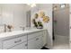 Bright bathroom featuring white cabinets, quartz countertop, decorative gold flowers and a walk-in shower at 7002 S Portland Ave, Gilbert, AZ 85298