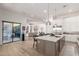 Open-concept kitchen with a granite island, wine storage, and stainless steel appliances at 7002 S Portland Ave, Gilbert, AZ 85298