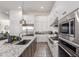 Gourmet kitchen with stainless appliances, white cabinetry, and a gray tiled backsplash at 7002 S Portland Ave, Gilbert, AZ 85298
