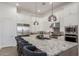 Large kitchen island with seating and granite countertops, stainless appliances, and white cabinetry at 7002 S Portland Ave, Gilbert, AZ 85298