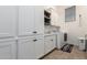 Laundry room featuring white cabinets, a sink, a washer, and a dryer, creating a functional space at 7002 S Portland Ave, Gilbert, AZ 85298