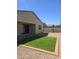 View of the backyard with artificial turf, rock landscaping, block fence and covered patio at 7321 N 123Rd Dr, Glendale, AZ 85307