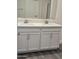Bathroom with double sink vanity, white cabinets, and silver faucets at 7321 N 123Rd Dr, Glendale, AZ 85307