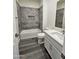 Modern bathroom featuring gray tile, a shower over the tub, and sleek fixtures at 7321 N 123Rd Dr, Glendale, AZ 85307