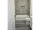 Bright bathroom featuring a tub with gray tile surround at 7321 N 123Rd Dr, Glendale, AZ 85307