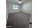 Bedroom featuring neutral carpet, a ceiling fan, and a large window at 7321 N 123Rd Dr, Glendale, AZ 85307