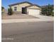 Tan single-story home with a stone veneer accent, desert landscaping, and a two car garage on a sunny day at 7321 N 123Rd Dr, Glendale, AZ 85307