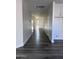 Hallway with gray wood-style floors leading to a white front door and additional rooms in the home at 7321 N 123Rd Dr, Glendale, AZ 85307