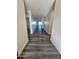 Hallway with gray wood flooring and white walls leading to the entrance of the house at 7321 N 123Rd Dr, Glendale, AZ 85307