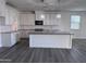 Bright kitchen with white cabinets, granite countertops, a large island and modern lighting fixtures at 7321 N 123Rd Dr, Glendale, AZ 85307