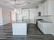 Bright kitchen with white cabinets, granite countertops, a large island and modern lighting fixtures at 7321 N 123Rd Dr, Glendale, AZ 85307