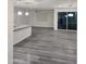 Bright, open-concept living room features gray wood-look floors, modern light fixtures and glass sliding doors at 7321 N 123Rd Dr, Glendale, AZ 85307