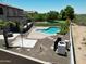 Backyard with pool, patio area, and a small yard with a view of neighboring rooftops at 7398 W Paso Trl, Peoria, AZ 85383