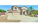Traditional two-story home featuring a three-car garage, desert landscaping, and a charming front entrance at 7398 W Paso Trl, Peoria, AZ 85383