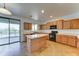 Bright kitchen with wooden cabinets, a center island, and sliding door access to the swimming pool at 7398 W Paso Trl, Peoria, AZ 85383
