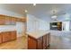Kitchen with an island, neutral countertops, wood cabinets, and open to the living room at 7398 W Paso Trl, Peoria, AZ 85383