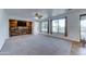 Large living room features wood accent wall, neutral carpet, tile entry and many windows looking out to pool and greenery at 7398 W Paso Trl, Peoria, AZ 85383