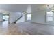 Spacious living room featuring plush carpet flooring, neutral walls, and ample natural light, with stairs to the second floor at 7398 W Paso Trl, Peoria, AZ 85383