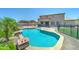 Inviting backyard pool featuring a safety fence, rock features, and desert landscaping at 7398 W Paso Trl, Peoria, AZ 85383