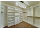 Gorgeous walk-in closet with custom built-in shelving, drawers, and a stunning chandelier for added elegance at 7398 W Paso Trl, Peoria, AZ 85383