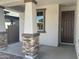 Inviting front porch featuring stone accents and a stylish, dark-stained front door at 804 W Lark Dr, Queen Creek, AZ 85140