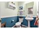 This quaint powder room features a pedestal sink, an elegant mirror, and wainscotting at 818 E Hiddenview Dr, Phoenix, AZ 85048