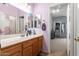 Charming bathroom featuring a wood vanity, mirrored wall, and adjacent walk-in closet at 818 E Hiddenview Dr, Phoenix, AZ 85048