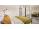 Spacious bedroom featuring a full-length mirrored closet, wood floors, and door to bathroom at 8210 E Garfield St # K23, Scottsdale, AZ 85257