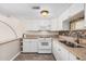 Bright kitchen with white cabinets, stone countertops, stainless-steel appliances, and modern lighting at 8210 E Garfield St # K23, Scottsdale, AZ 85257