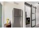 Modern stainless steel refrigerator next to gray sliding door in well lit kitchen at 8210 E Garfield St # K23, Scottsdale, AZ 85257