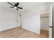 Well-lit bedroom with wood-look flooring, a ceiling fan, and a walk-in closet at 830 S Dobson Rd # 19, Mesa, AZ 85202
