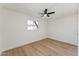 Minimalist bedroom featuring wood flooring, a ceiling fan, neutral paint, and a bright window at 830 S Dobson Rd # 19, Mesa, AZ 85202