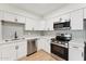 Updated kitchen with stainless steel appliances, white cabinetry, gray subway tile backsplash, and wood flooring at 830 S Dobson Rd # 19, Mesa, AZ 85202