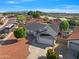 An aerial view shows a well-maintained home in a quiet neighborhood with mountain views at 8620 W Denton Ln, Glendale, AZ 85305